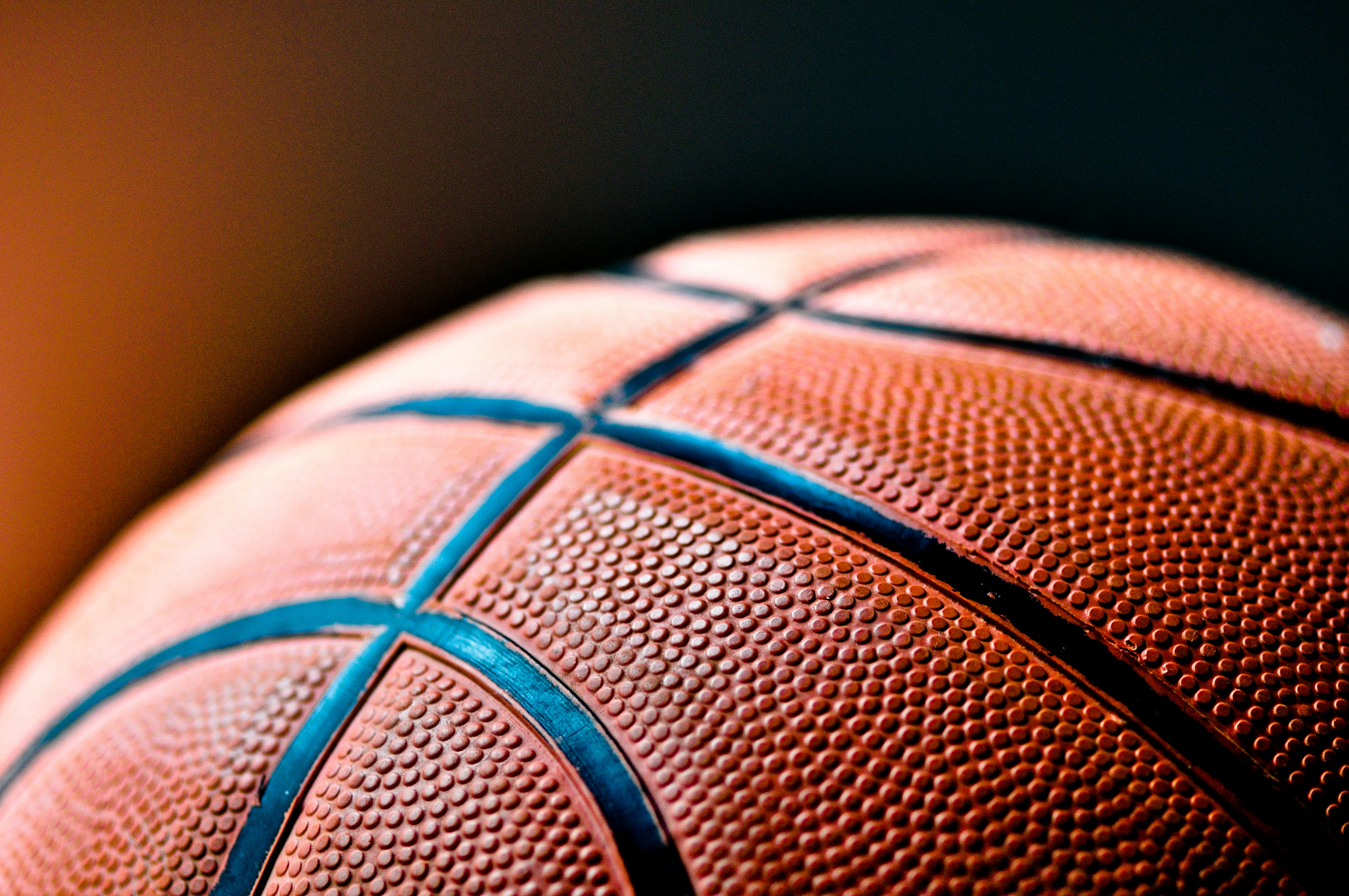 Nahaufnahme eines Basketballs mit sichtbarer Struktur und schwarzen Linien.
